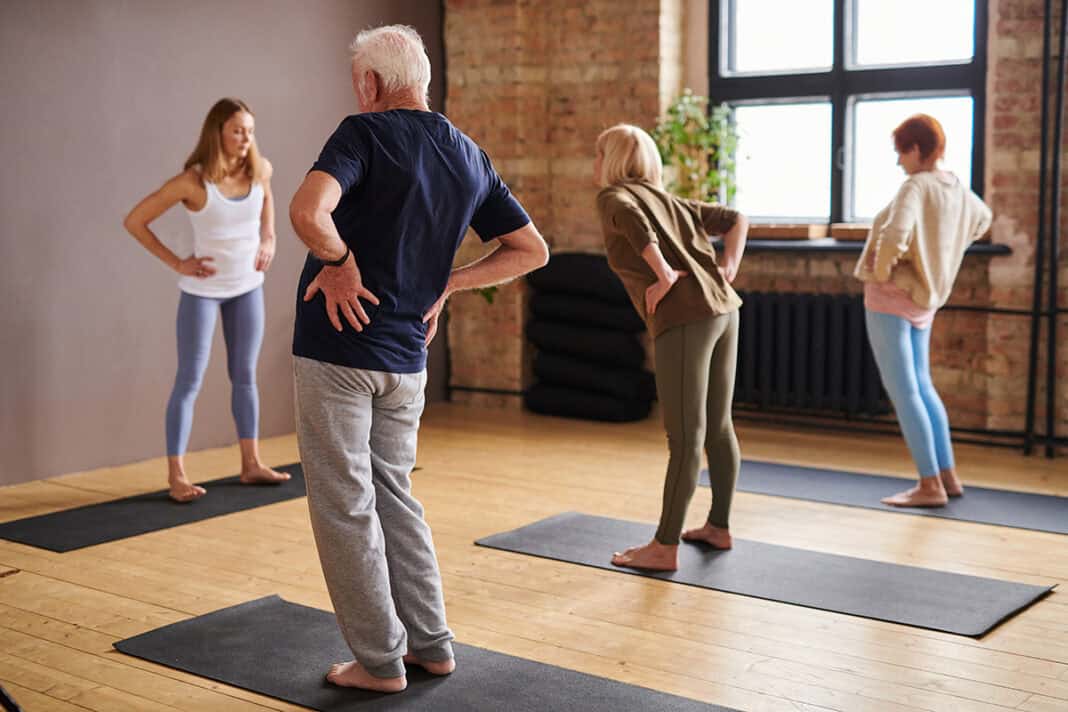 Young female trainer and group of senior people doing physical exercise Seniorensport in Flensburg