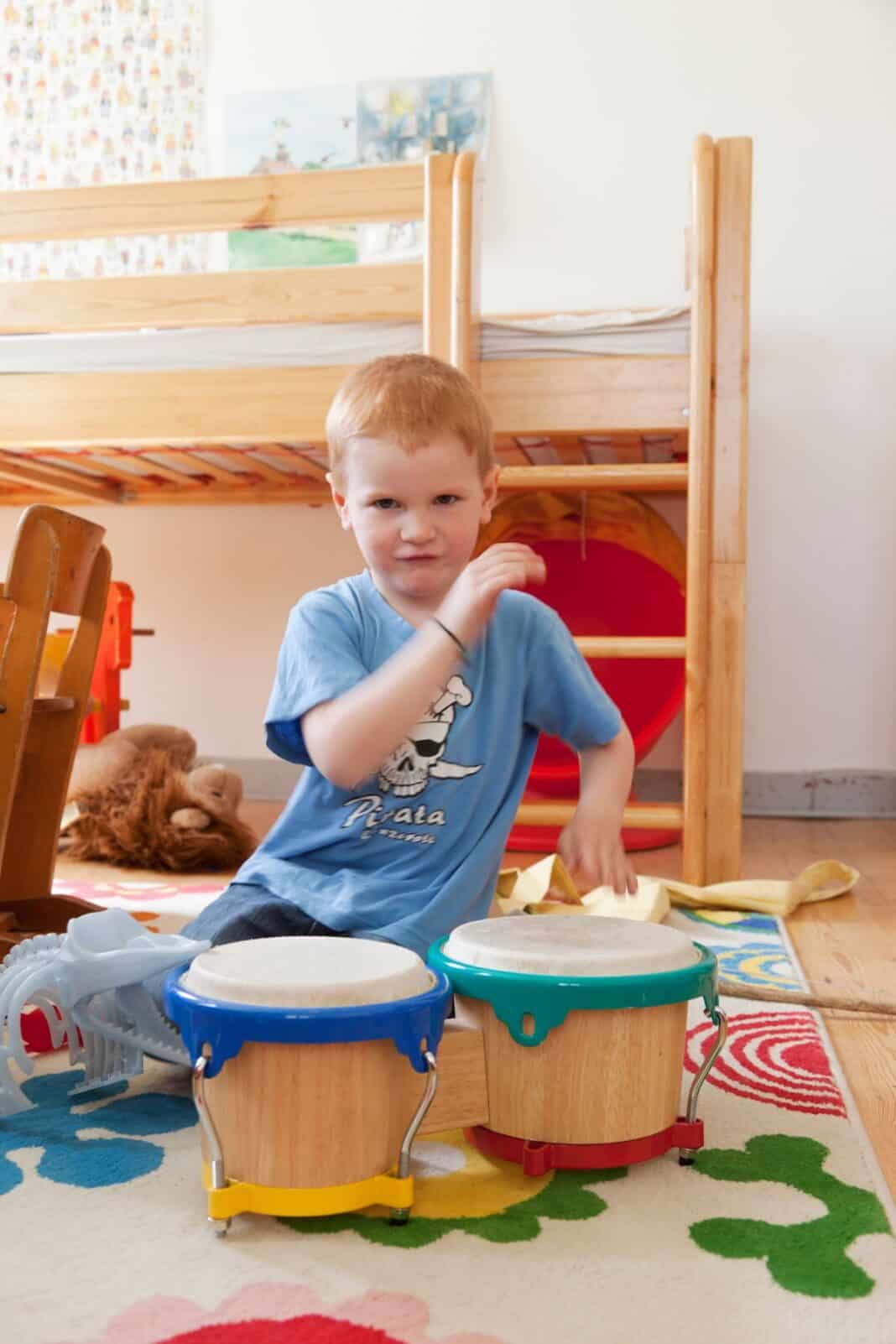 Boy playing with toy drums Dauerbeschallung im Kinderzimmer - Warum auch Ohren Pausen brauchen