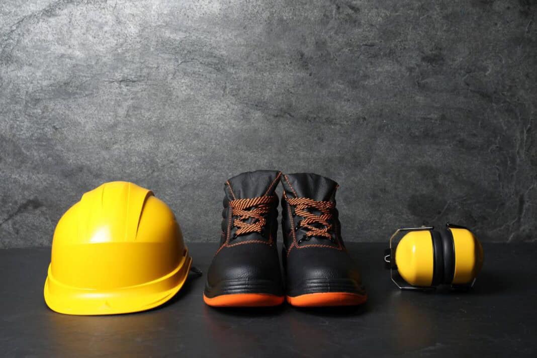 yellow-hard-hat-safety-boots-and-earmuffs-on-dark-2026-08-05-03-05-36-utc Wie moderne Sicherheitsschuhe S3 die Gesundheit am Arbeitsplatz schützen